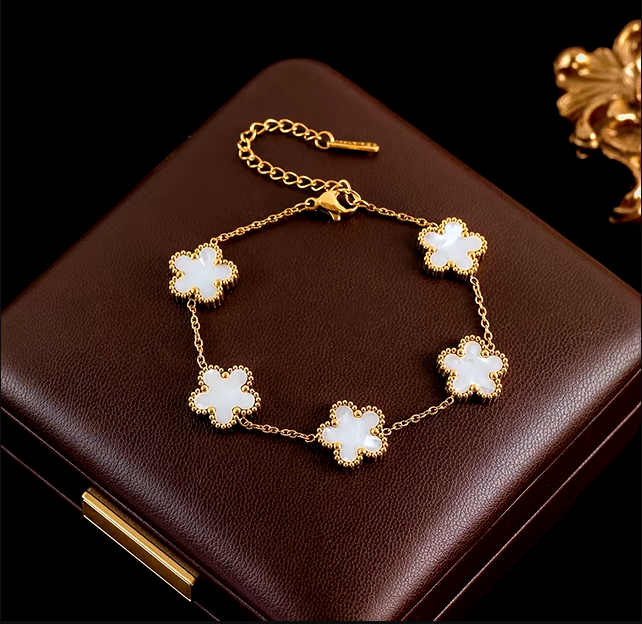 Bracelet, collier et boucles d'oreilles avec motifs floraux blanc.